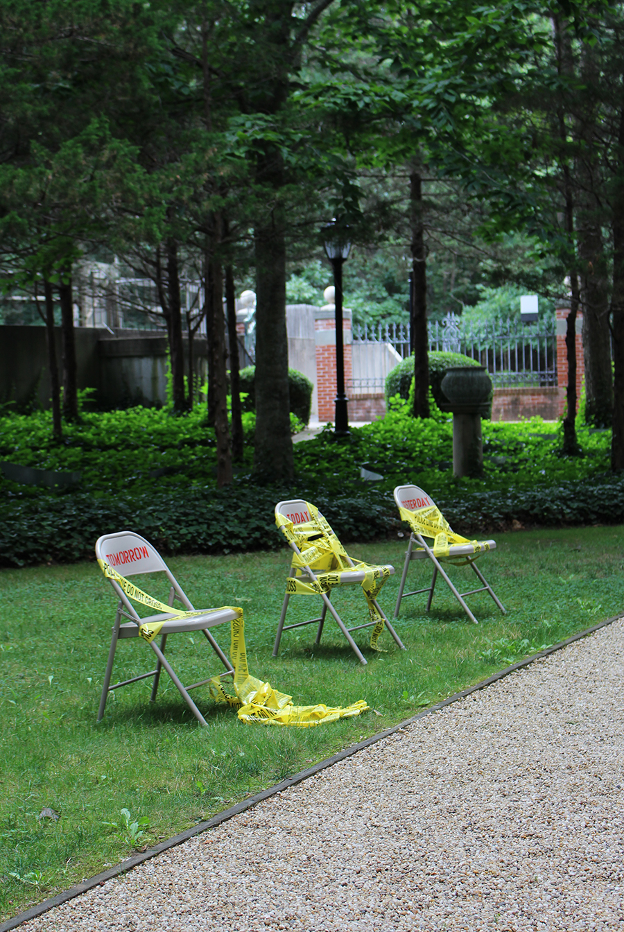 DIVIDED WE STAND, 2020 3 hand-stenciled metal folding chairs, police tape' 40 x 192 x 48 inches